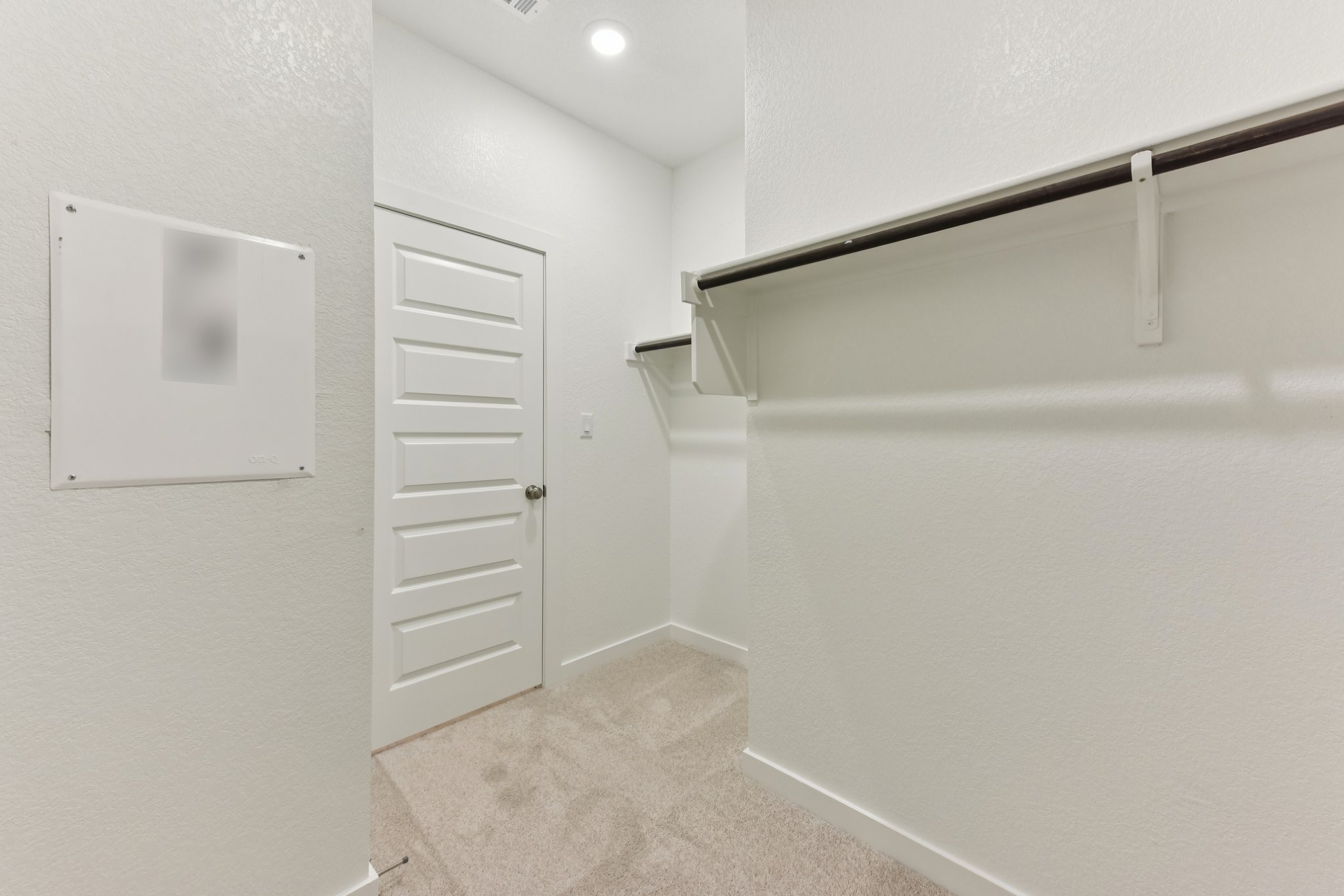 A hallway with white cabinets.