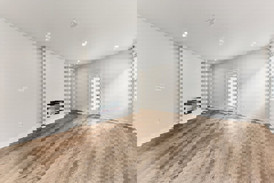 A room with a wood floor and a fireplace.