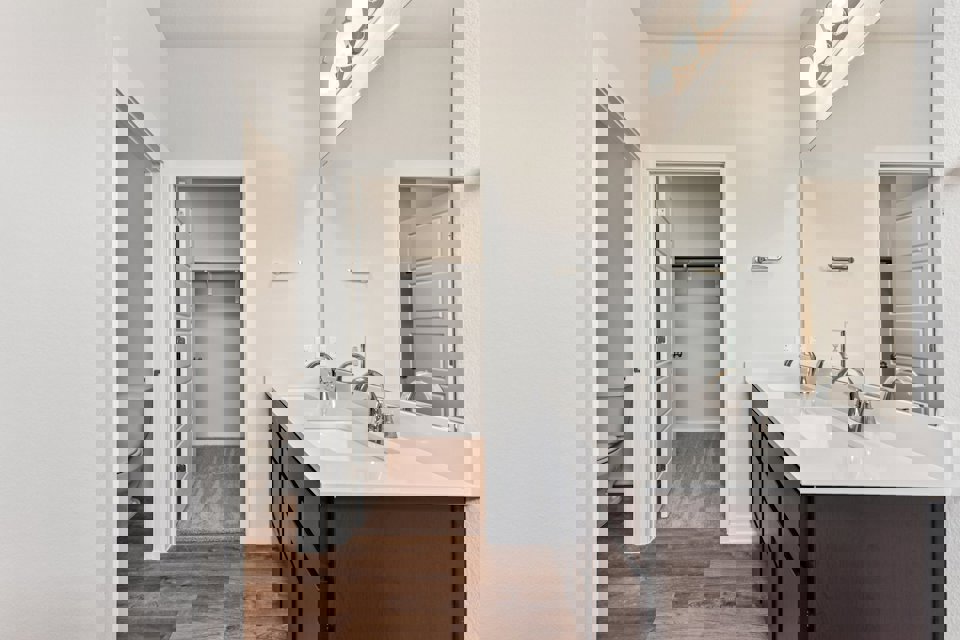 A bathroom with a sink toilet and mirror.