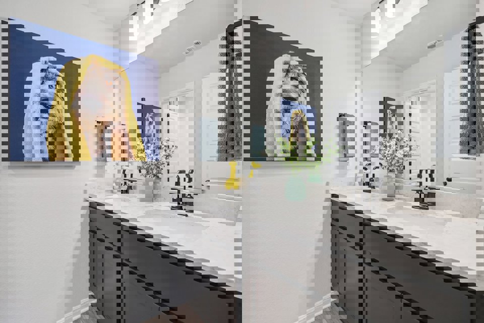 A bathroom with a painting on the wall.