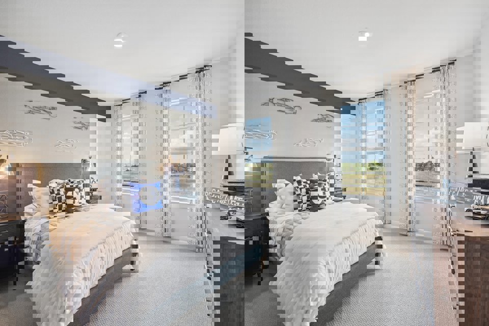 A bedroom with a large window.