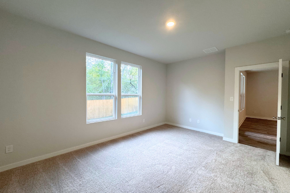 A room with a carpet and windows.