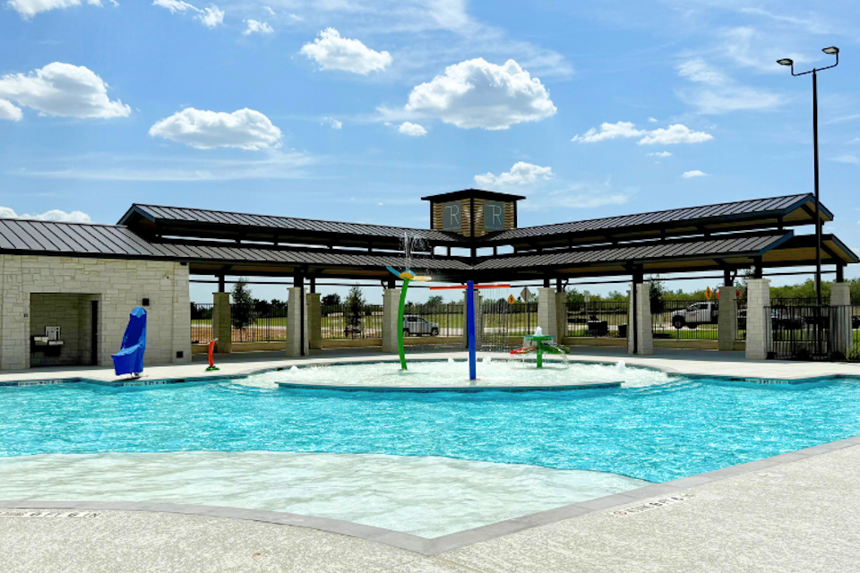 A swimming pool in front of a building.