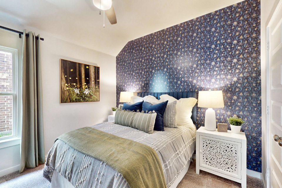 A bedroom with a bed and a lamp.