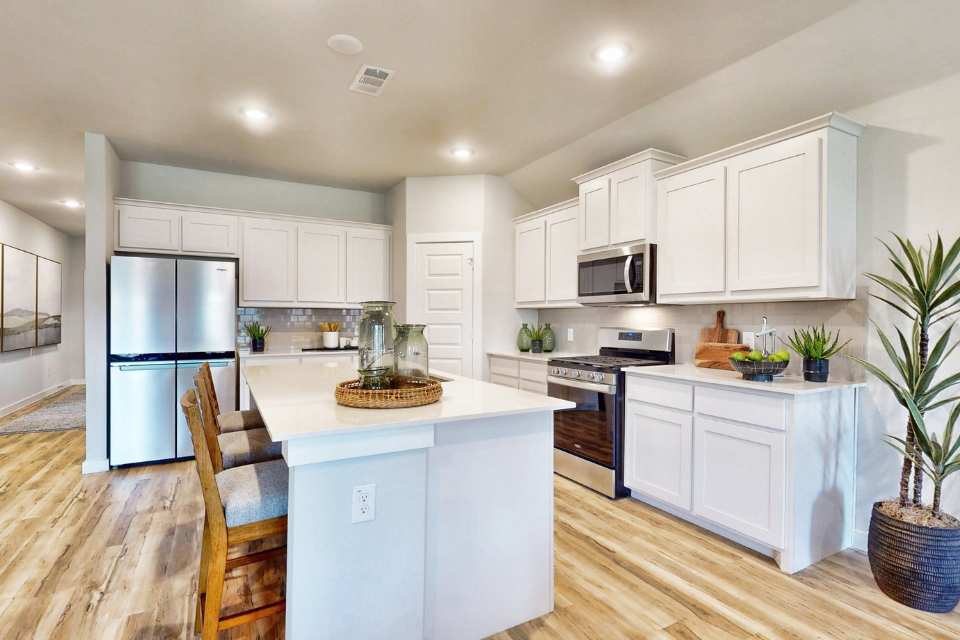 A kitchen with white cabinets.