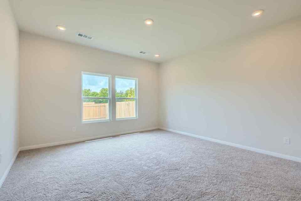 A room with a window and a carpet.