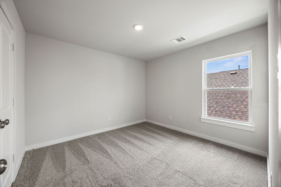 A room with a window and a carpet.