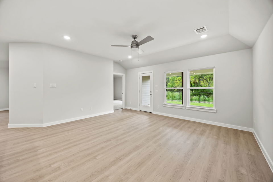 A room with a wood floor and a ceiling fan.