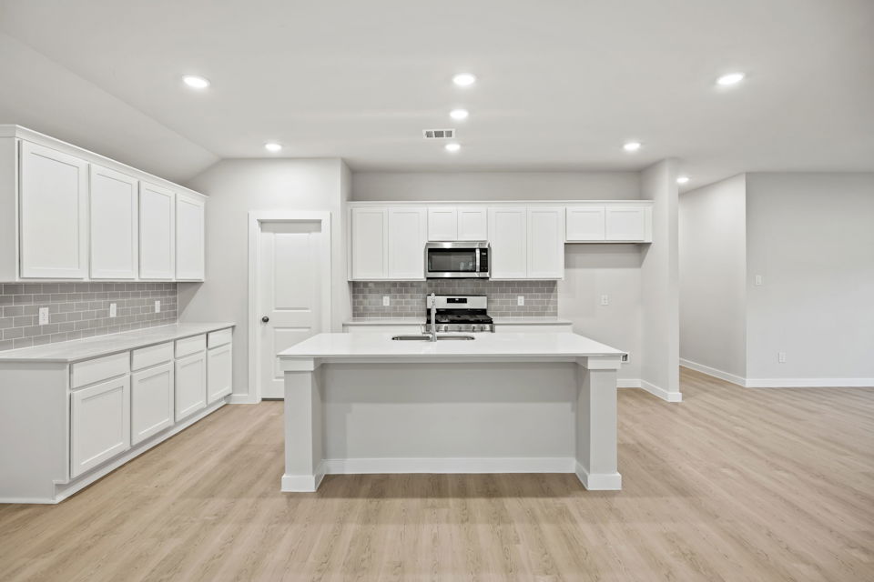 A kitchen with white cabinets.