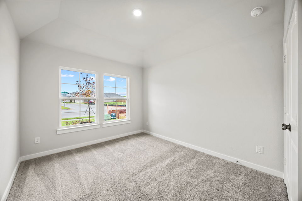 A room with a carpet and a window.