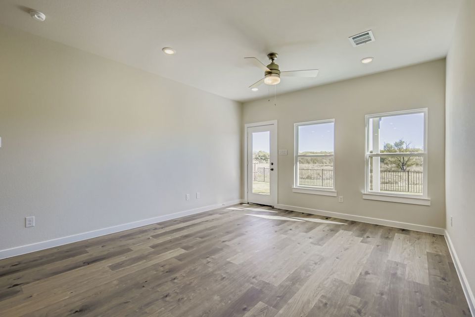 A room with a wood floor and a ceiling fan.