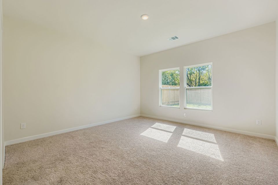 A room with a carpet and windows.