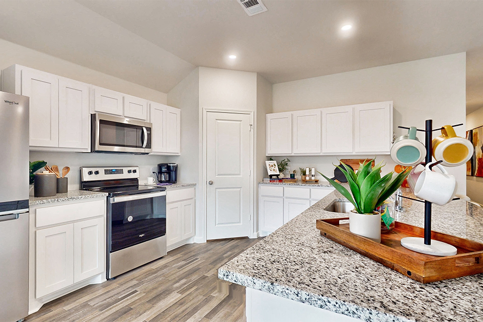 A kitchen with white cabinets.