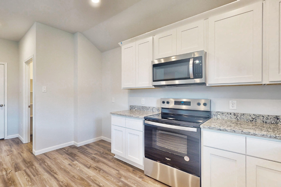 A kitchen with white cabinets.