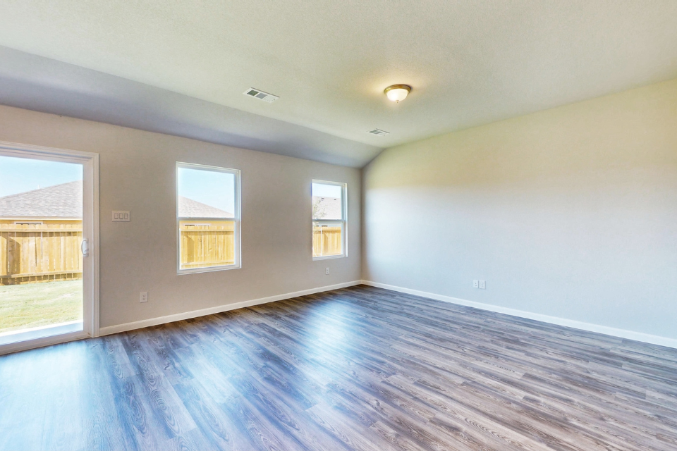 A room with windows and a wood floor.