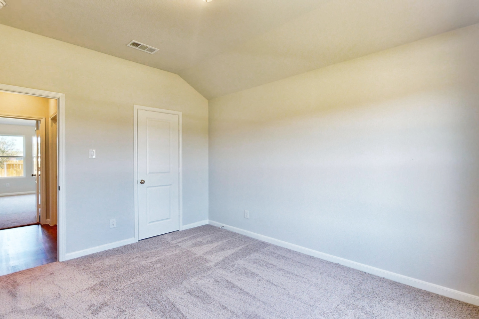 A room with a white wall and a door.