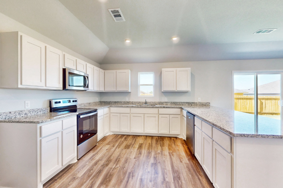 A kitchen with white cabinets.