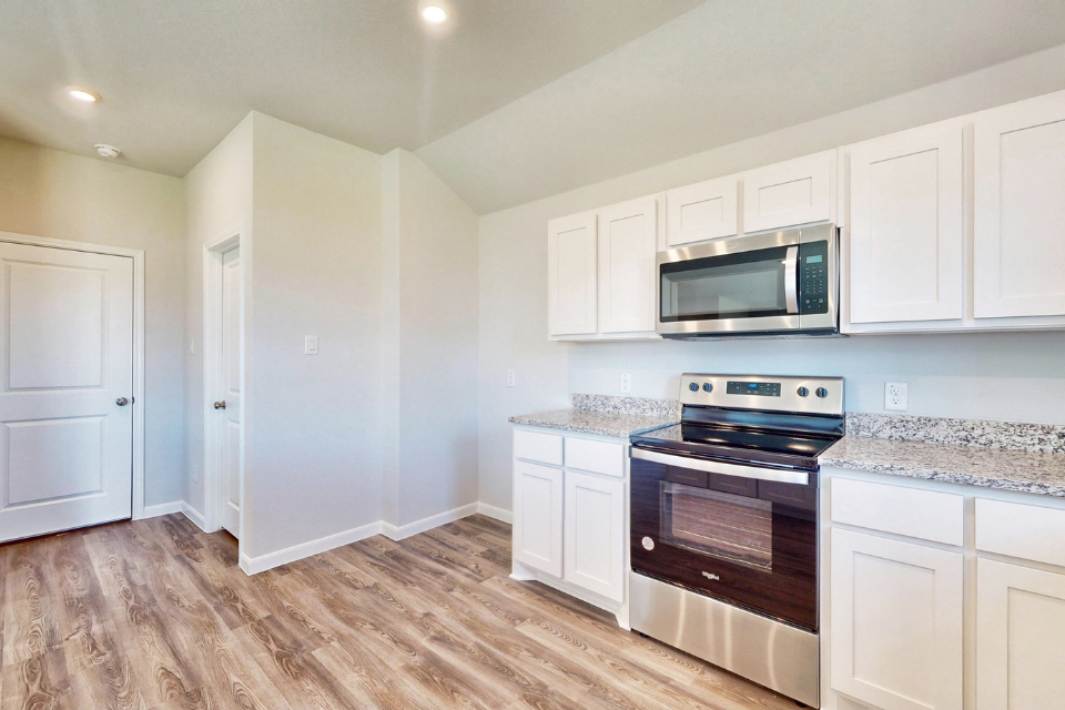 A kitchen with white cabinets.