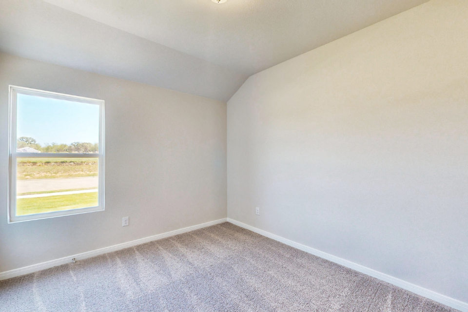 A room with a window and a carpet.