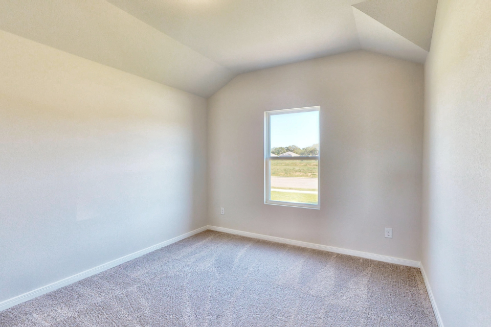 A room with a window and carpet.