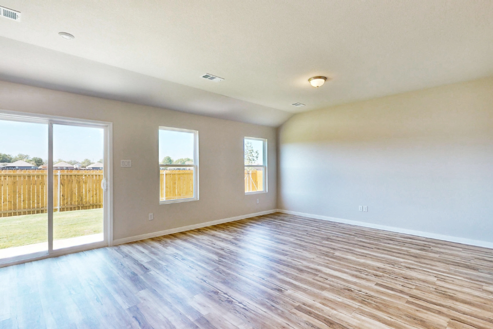 A room with windows and a wood floor.