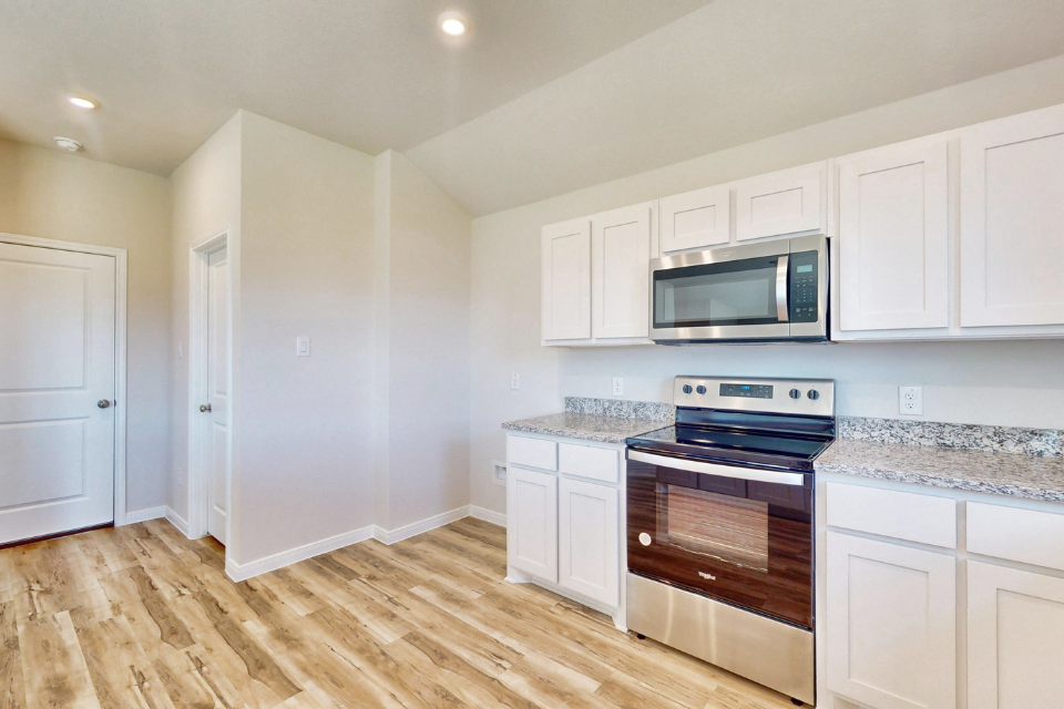 A kitchen with white cabinets.