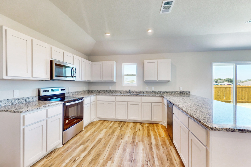 A kitchen with white cabinets.