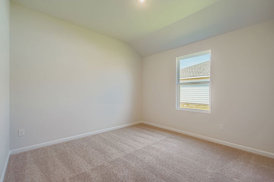 A room with a carpet and a window.