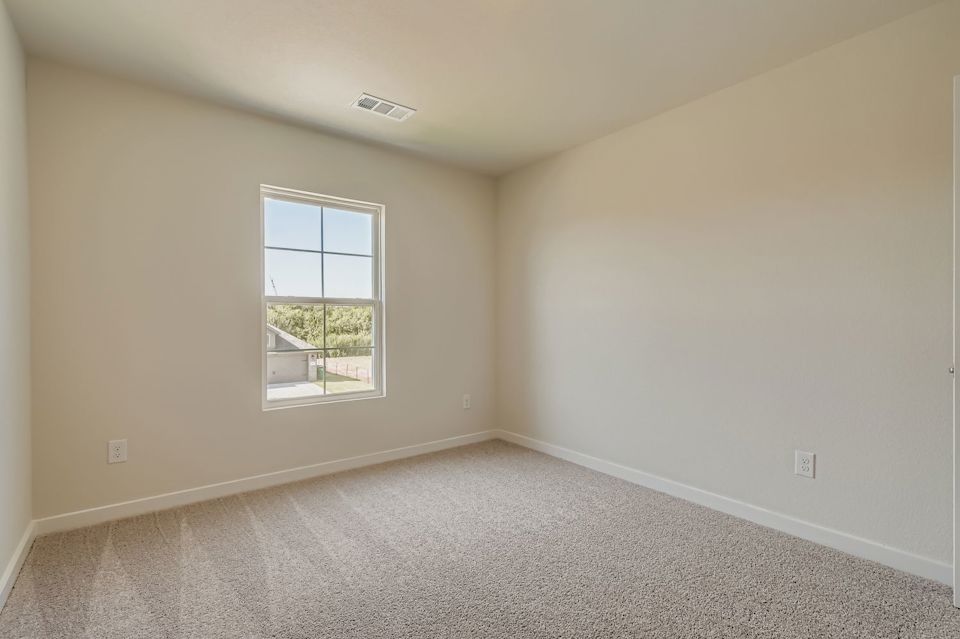 A room with a window and carpet.