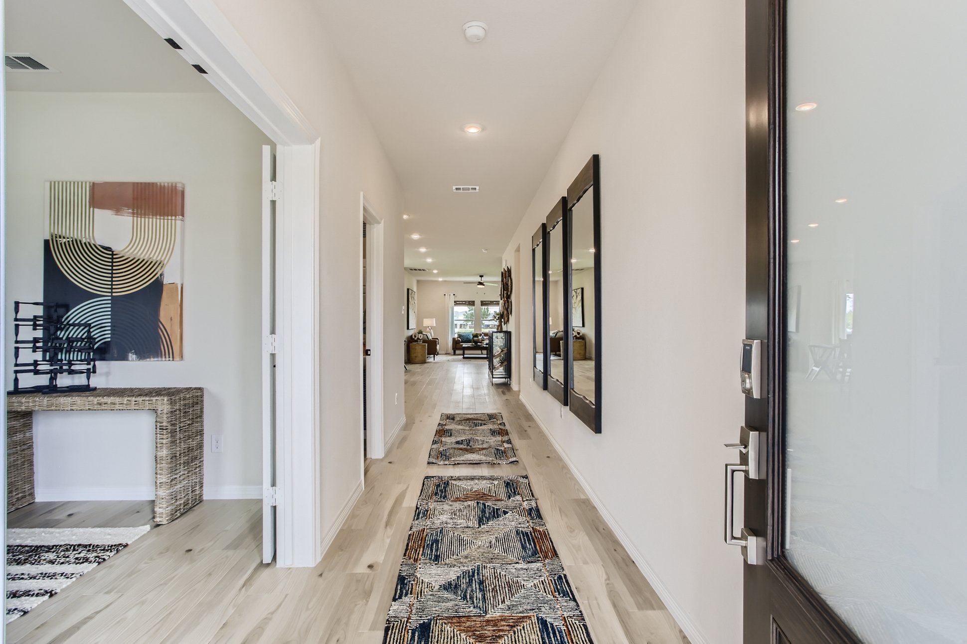 A hallway with a rug and a mirror.