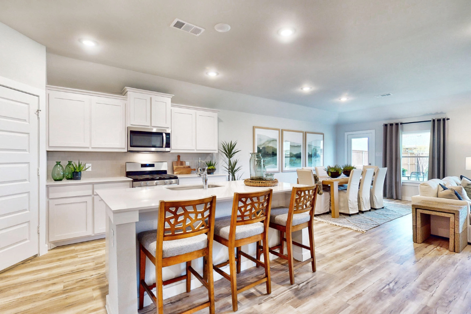 A kitchen with a dining table and chairs.
