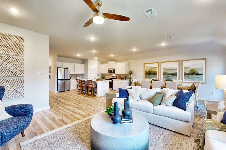 A large living room with a large chandelier and a large white couch.