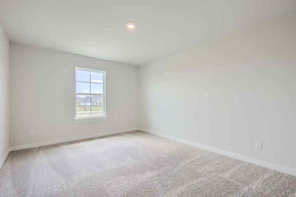 A room with a window and carpet.