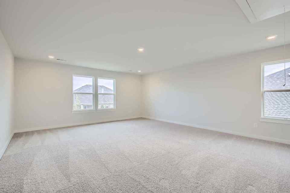 A room with a carpet and windows.