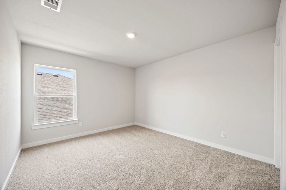 A room with a window and carpet.