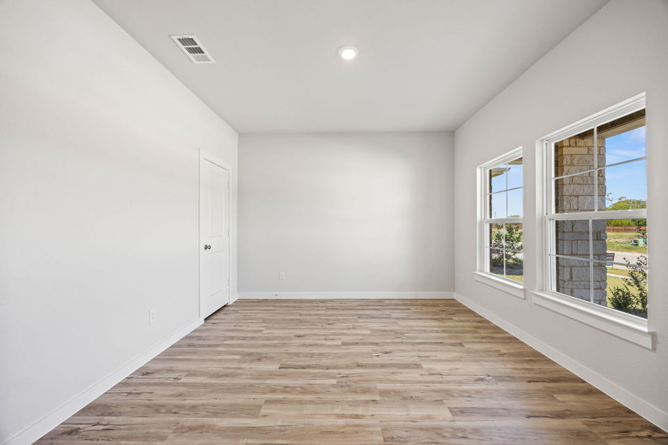 A room with windows and wood floor.