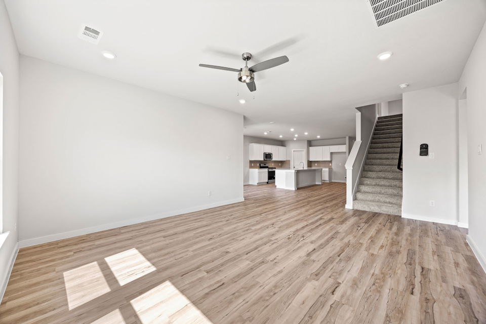 A large empty room with a wood floor and a wood floor.