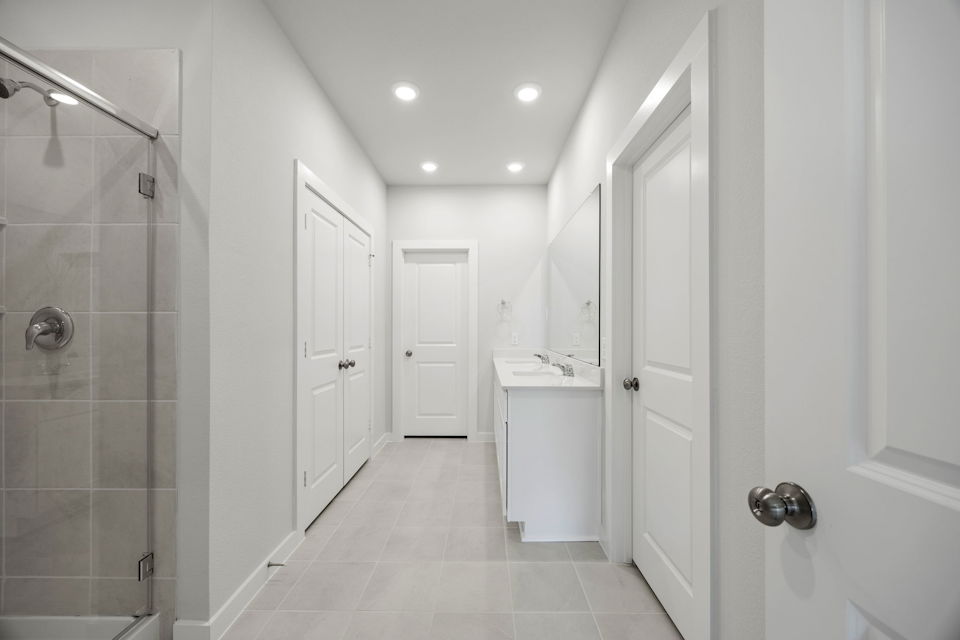 A bathroom with white cabinets.