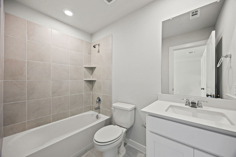 A bathroom with a tub toilet and sink.