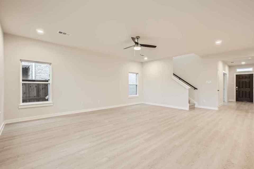 A room with a wood floor and a ceiling fan.