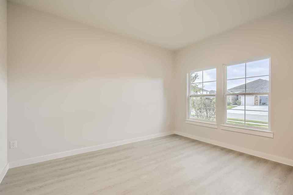 A room with a window and a wood floor.