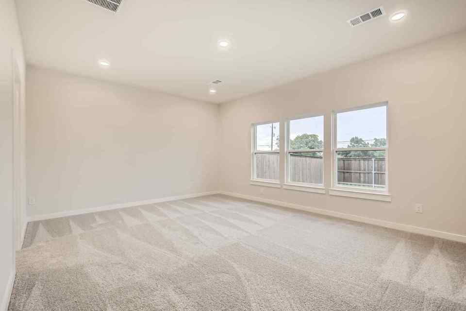 A room with a carpet and windows.