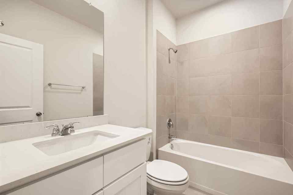 A bathroom with a tub sink and toilet.