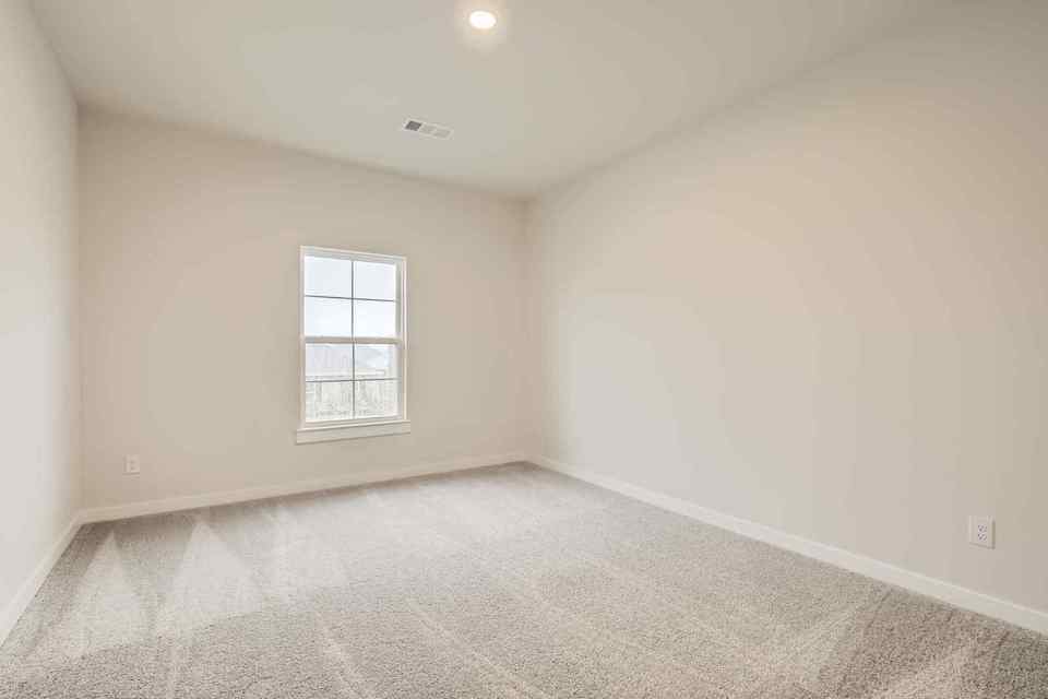 A room with a window and carpet.