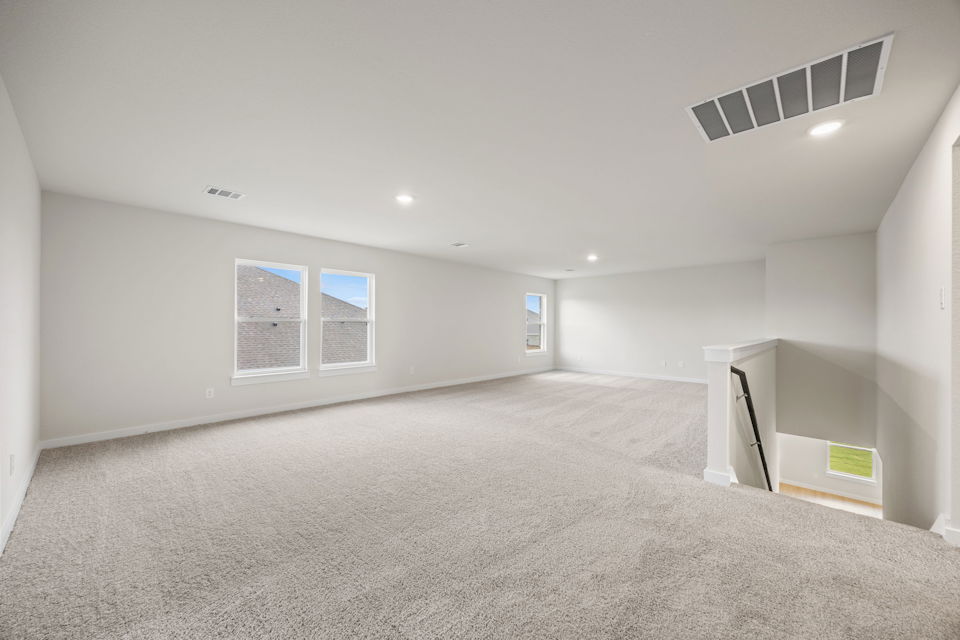 A room with a carpet and a vent.