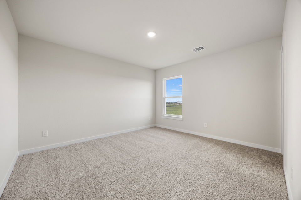 A room with a window and carpet.