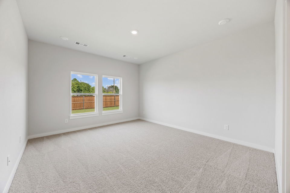 A room with a window and a carpet.