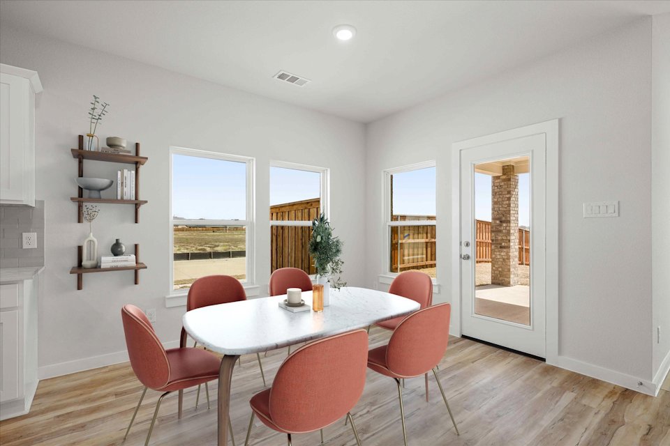 A dining room with a table and chairs.