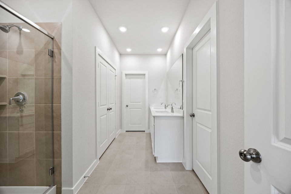 A bathroom with white cabinets.