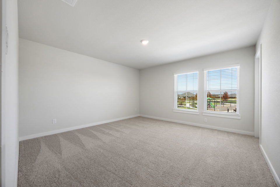 A room with a carpet and windows.